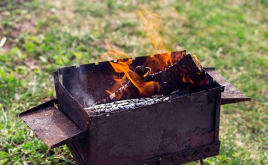 Yakacak odun dışarıda barbeküde yanıyor.