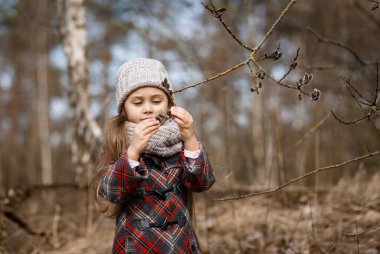 little cute girl in spring forest and pussy-willow twigs