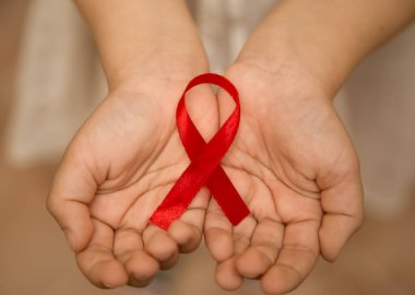 Aids sembolü ellerinde küçük kırmızı kurdele