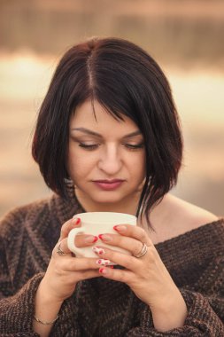 Genç tatlı kız açık havada kahve içiyor.