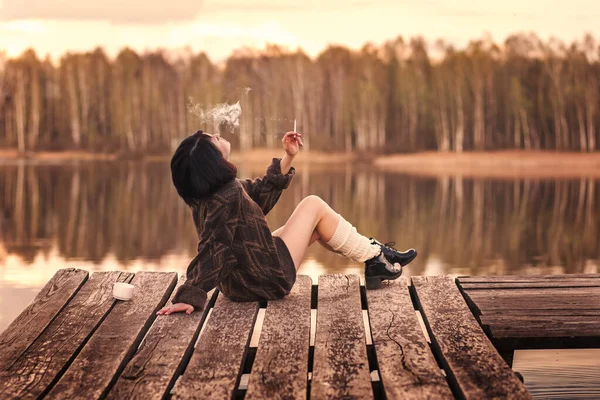 夏の大自然の中で思慮深くタバコを吸う若い可愛い女の子 — ストック写真