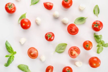 Beyaz arka planda olgun kırmızı kiraz domatesleri ve mozzarella. Üst görünüm