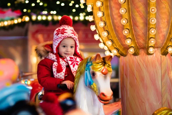 Child riding carousel on Christmas market — Stock Photo, Image