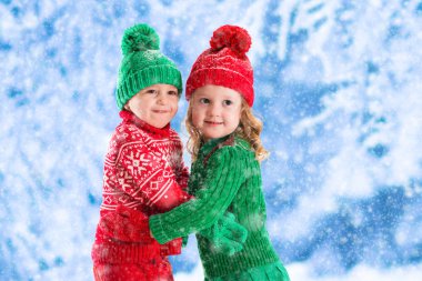 Karlı kış ormanda oynayan çocuklar