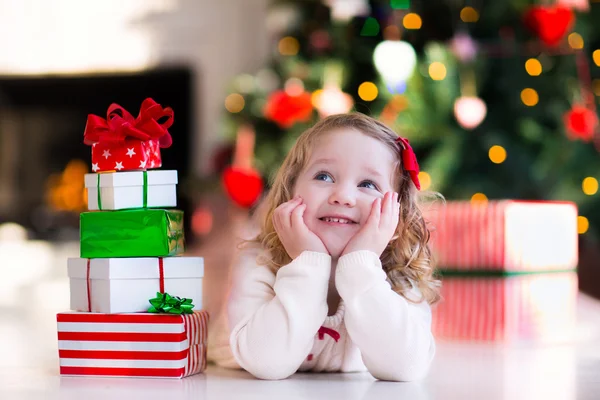 開く少女は、クリスマスの朝にプレゼントします。 — ストック写真