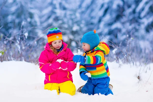 Bambini che giocano nel parco invernale innevato — Foto Stock