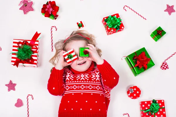 Liten flicka öppnar julklappar — Stockfoto