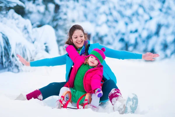 Mor och barn pulka i en snöig park — Stockfoto