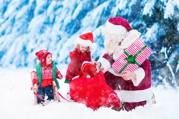 Crianças e Papai Noel com presentes de Natal — Fotografia de Stock