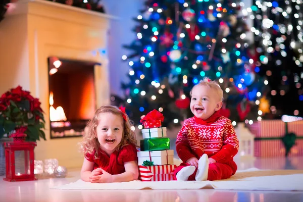 Kinderen spelen bij open haard op kerstavond — Stockfoto