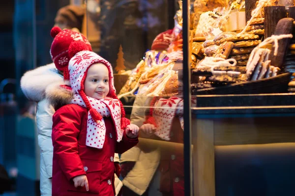 Дети смотрят на конфеты и кондитерские изделия на рождественском рынке — стоковое фото