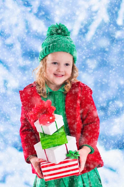 クリスマスを保持している小さな女の子を提示します。 — ストック写真