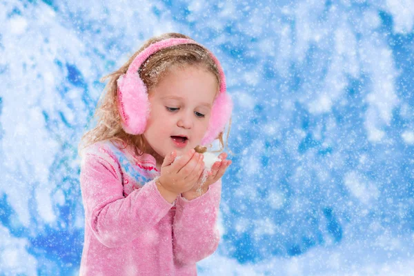 Little girl catching snow flakes