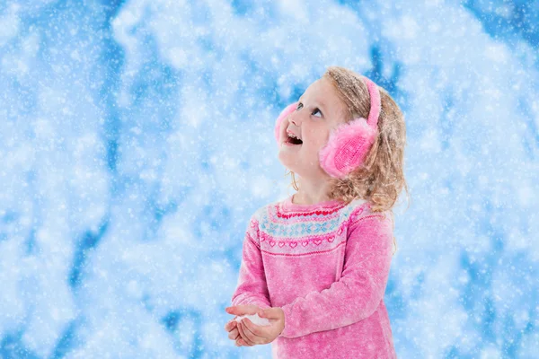 Malá dívka lov sněhových vloček — Stock fotografie