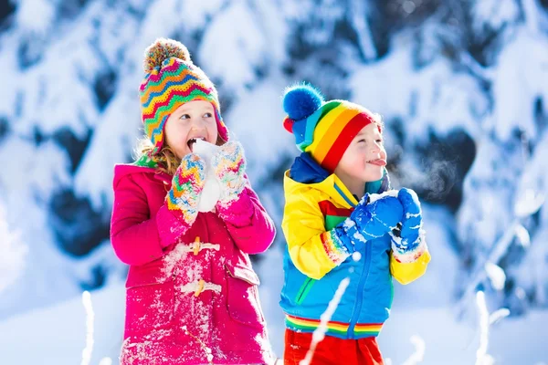 Children having fun in snowy winter park