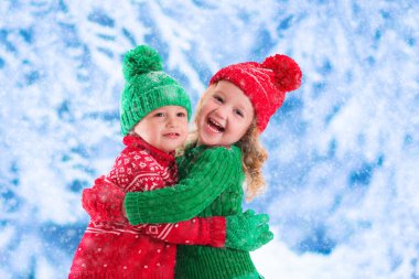 Karlı kış ormanda oynayan çocuklar