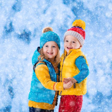 Çocuklar kışın dışarıda oynuyorlar.