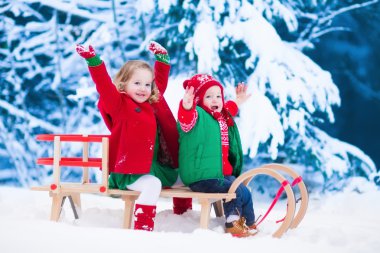 Çocuklar eğleniyor bir kızak üzerinde kışın binmek