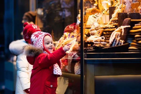 Kinder schauen sich auf Weihnachtsmarkt Süßigkeiten und Gebäck an — Stockfoto