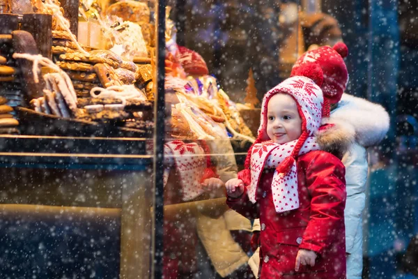 Kinder schauen sich auf Weihnachtsmarkt Süßigkeiten und Gebäck an — Stockfoto