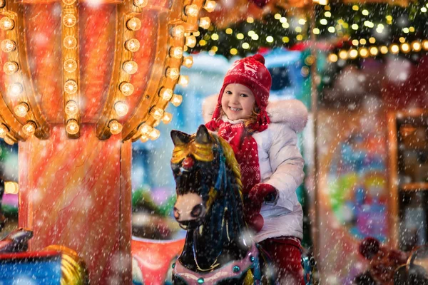 Child riding carousel on Christmas market — Stock Photo, Image