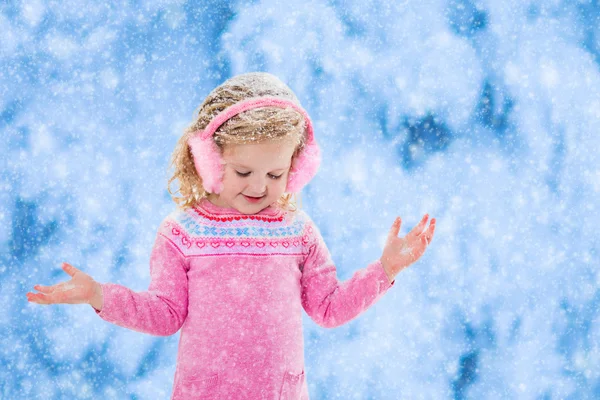 Little girl catching snow flakes — Stock Photo, Image