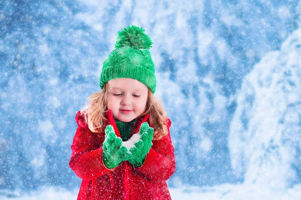 雪の降る公園で遊ぶ少女 — ストック写真