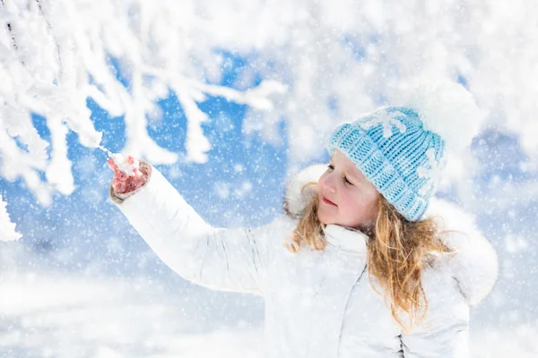 Child having fun in snowy winter park Royalty Free Stock Images
