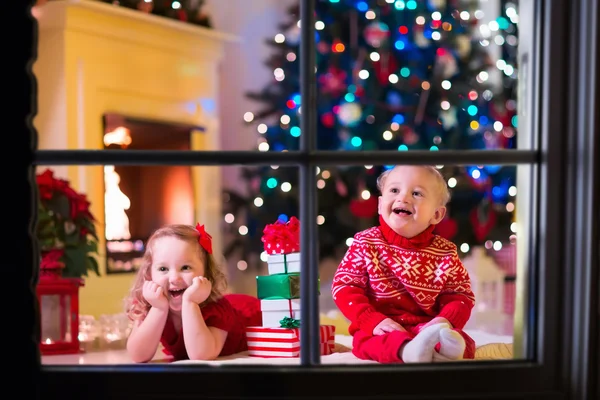 Şömine Noel arifesinde oynayan çocuklar — Stok fotoğraf