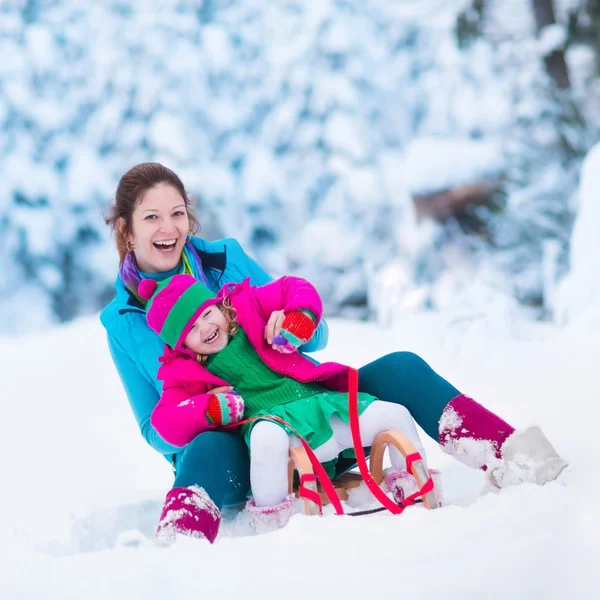 Madre e hijo en trineo en un parque cubierto de nieve —  Fotos de Stock