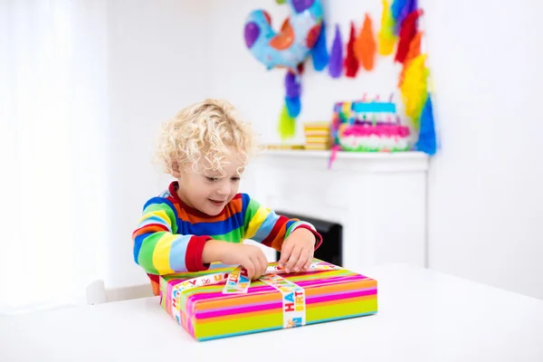 Küçük çocuk doğum günü açılış sunar — Stok fotoğraf