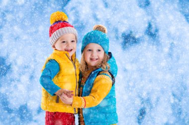 Çocuklar kışın dışarıda oynuyorlar.