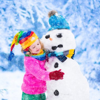 Küçük kız bir kar adam kışın bina