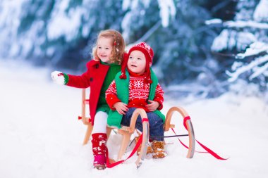 Çocuklar eğleniyor bir kızak üzerinde kışın binmek