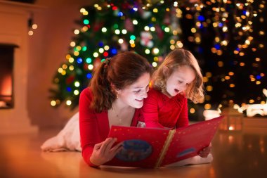 Anne ve kızı yangın yeri Noel arifesinde okuma