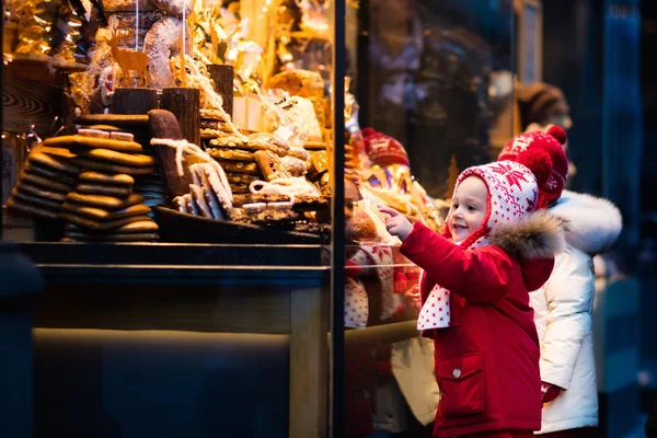 Дети смотрят на конфеты и кондитерские изделия на рождественском рынке — стоковое фото