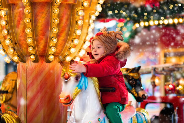 Child riding carousel on Christmas market