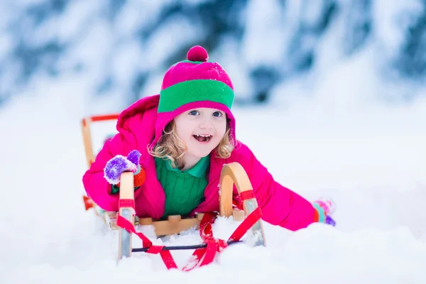 Malá holčička se těší jízda na saních v zimě — Stock fotografie