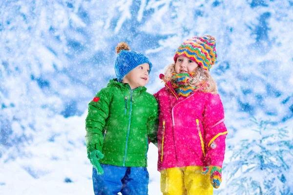 Τα παιδιά που παίζουν στο χιονισμένο χειμώνα πάρκο — Φωτογραφία Αρχείου