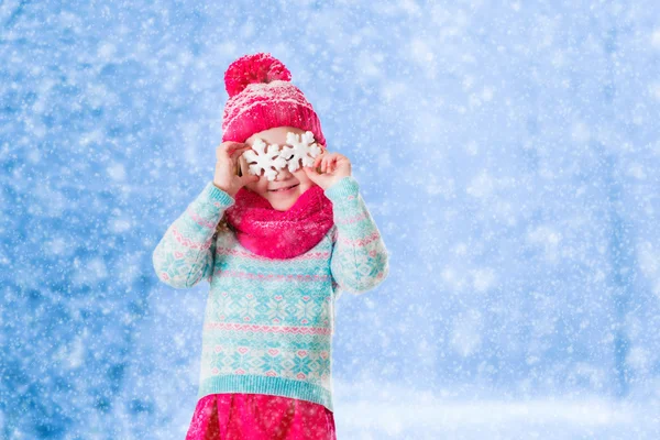Menina brincando com flocos de neve de brinquedo no parque de inverno — Fotografia de Stock