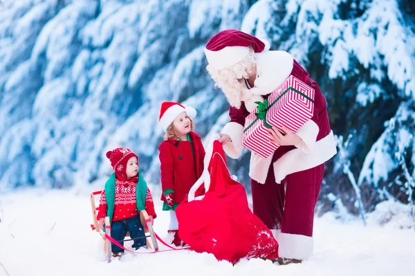 Crianças e Papai Noel com presentes de Natal — Fotografia de Stock