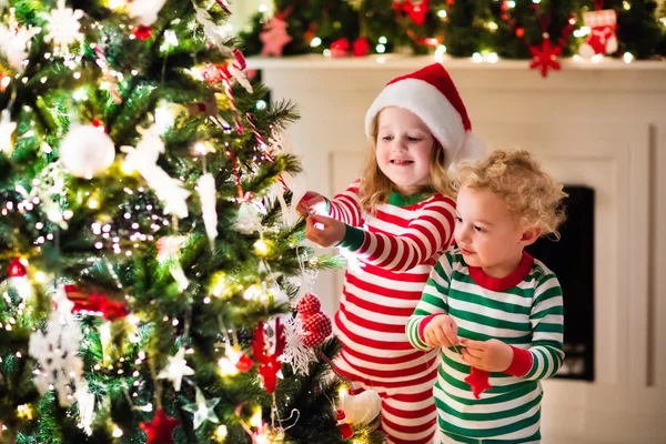 Niños en pijama bajo el árbol de Navidad — Foto de Stock