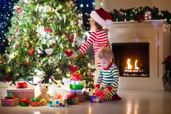 Niños en pijama bajo el árbol de Navidad —  Fotos de Stock