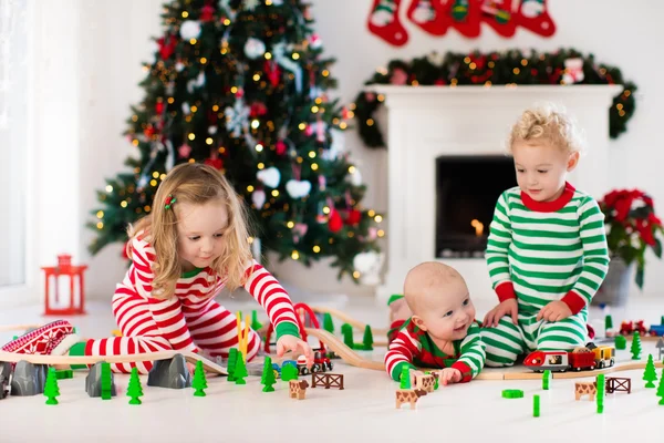 Niños jugando con el ferrocarril de juguete en la mañana de Navidad —  Fotos de Stock