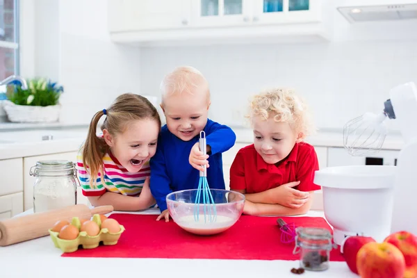 Kinderen bakken een taart in witte keuken — Stockfoto