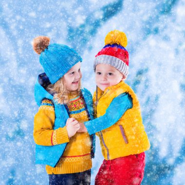 Çocuklar kışın dışarıda oynuyorlar.