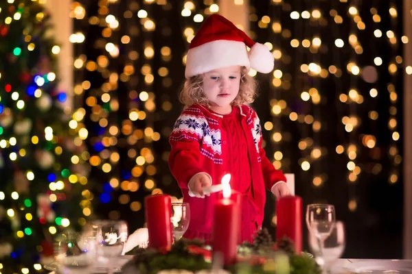 Liten flicka tända ljus på julbord — Stockfoto