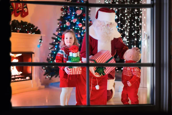 Kinder und Weihnachtsmann eröffnen Weihnachtsgeschenke — Stockfoto