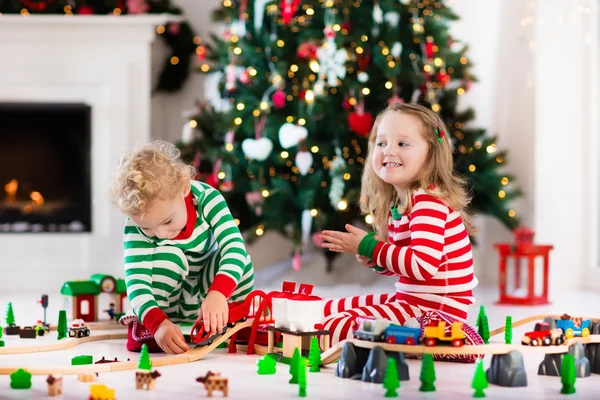 クリスマスの朝にグッズ鉄道と遊ぶ子供たち — ストック写真