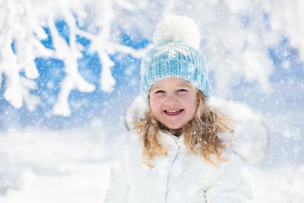 Παιδί διασκεδάζοντας στο χιονισμένο χειμώνα πάρκο — Φωτογραφία Αρχείου